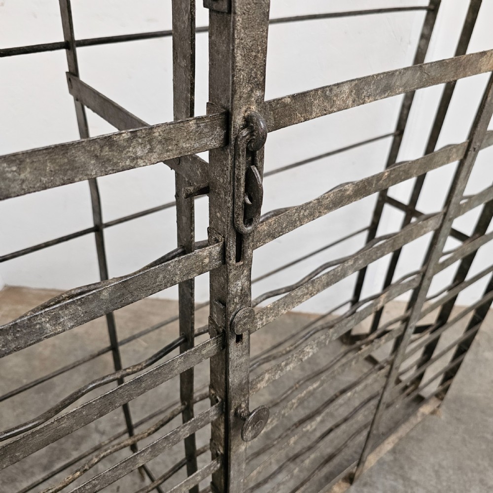 A large French dark iron lockable wine cage with double doors and horizontal bottle slots designed to hold 96 bottles. View III