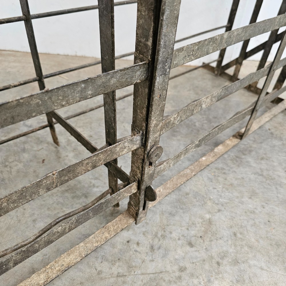 A large French dark iron lockable wine cage with double doors and horizontal bottle slots designed to hold 96 bottles. View V