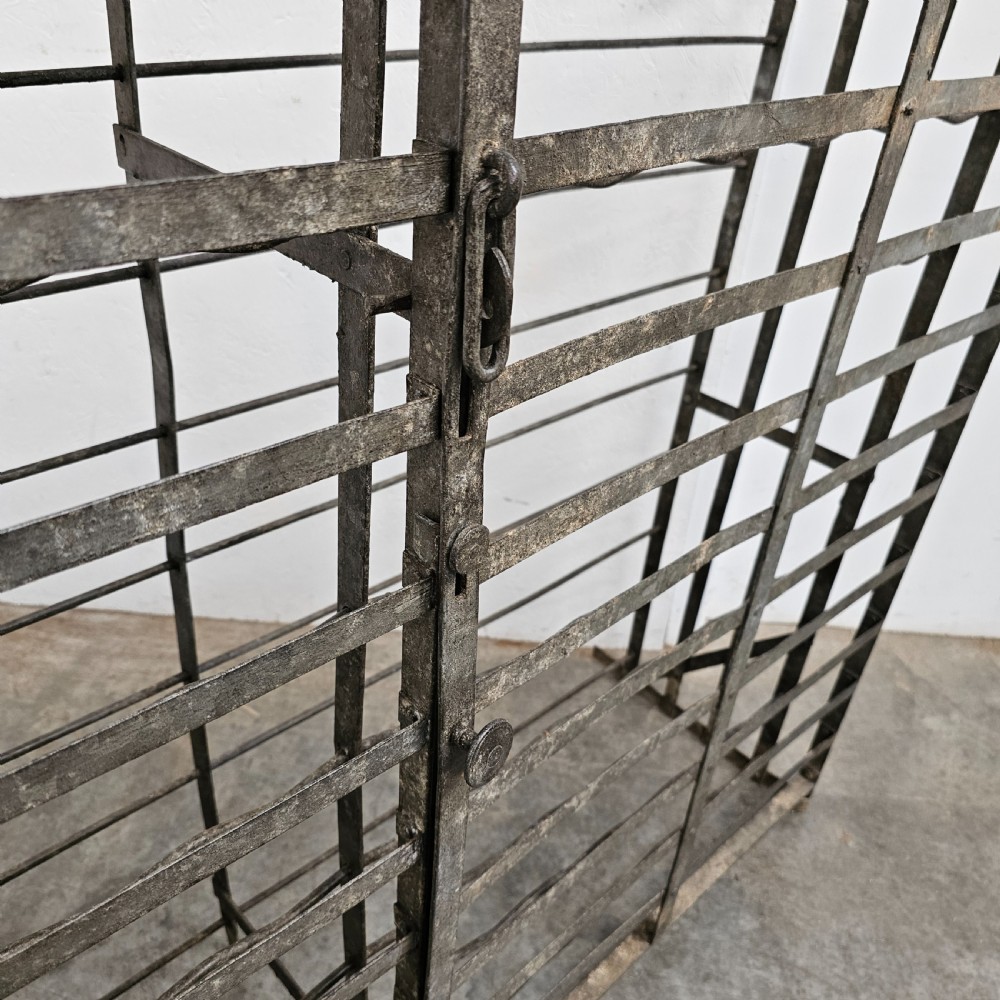 A large French dark iron lockable wine cage with double doors and horizontal bottle slots designed to hold 96 bottles. View VI