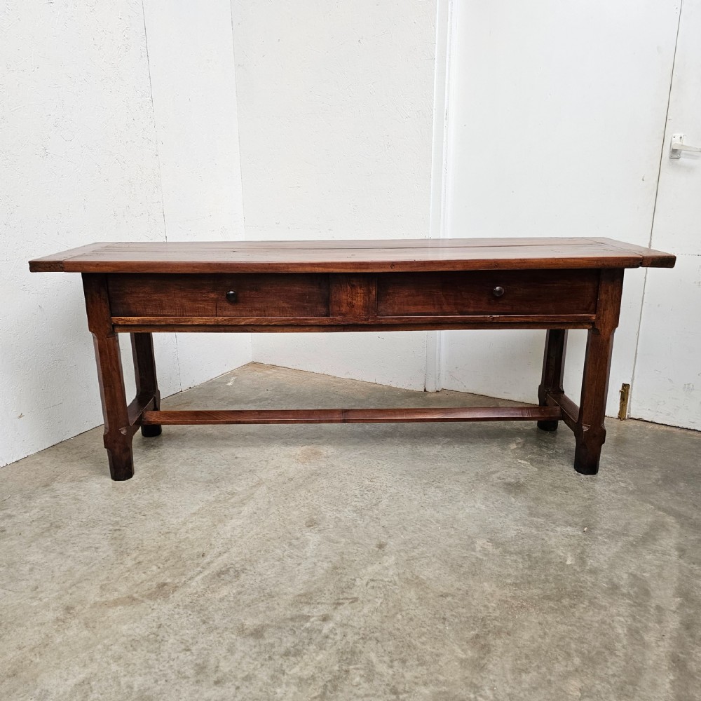 A long 19th-century dark brown wooden bread prep table featuring two drawers with round knobs and a low horizontal stretcher.