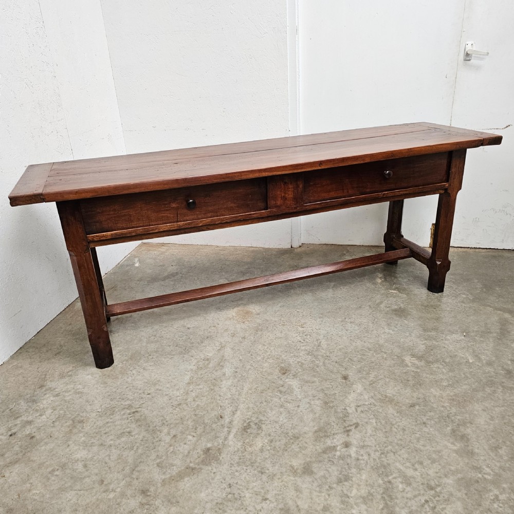 A long 19th-century dark brown wooden bread prep table featuring two drawers with round knobs and a low horizontal stretcher. View II