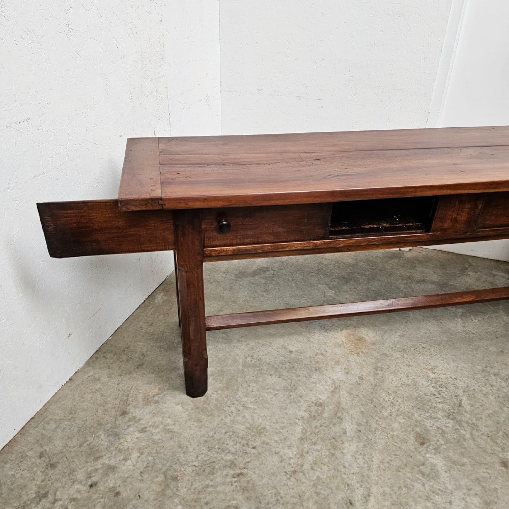 A long 19th-century dark brown wooden bread prep table featuring two drawers with round knobs and a low horizontal stretcher. View VI