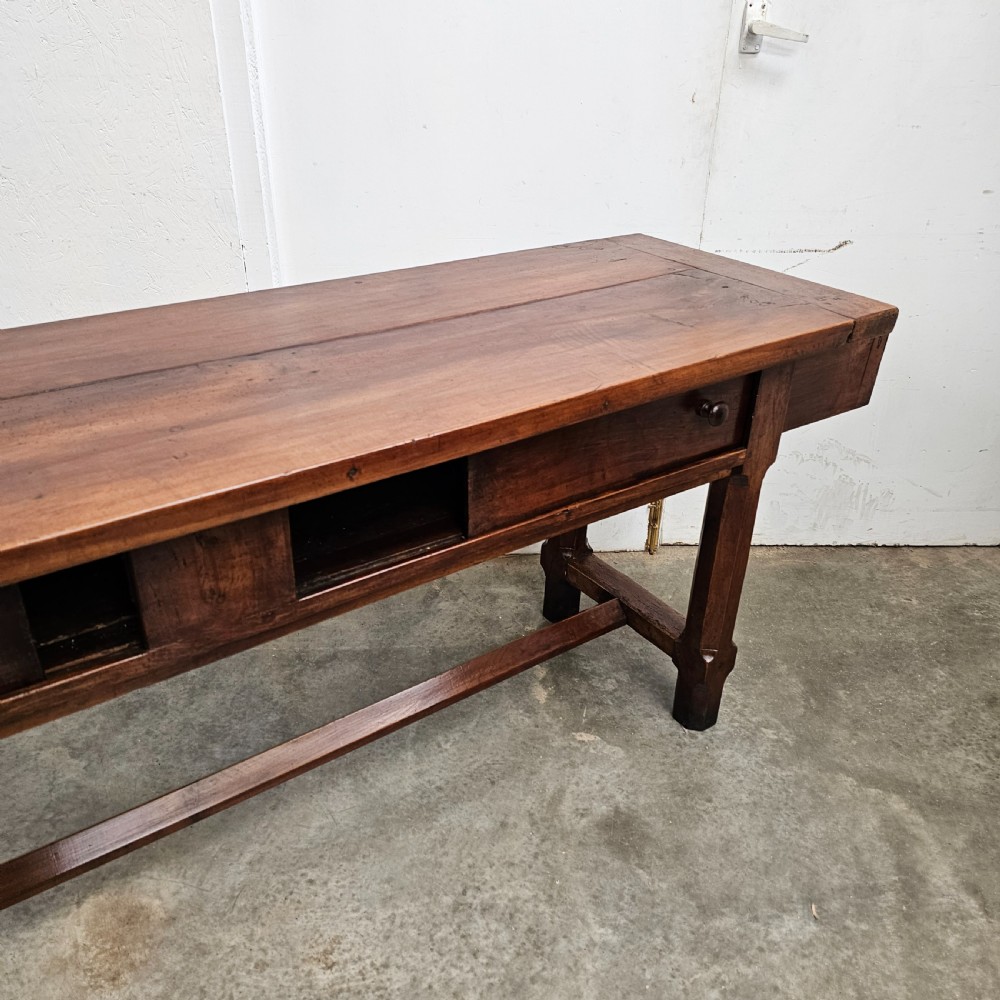 A long 19th-century dark brown wooden bread prep table featuring two drawers with round knobs and a low horizontal stretcher. View VII