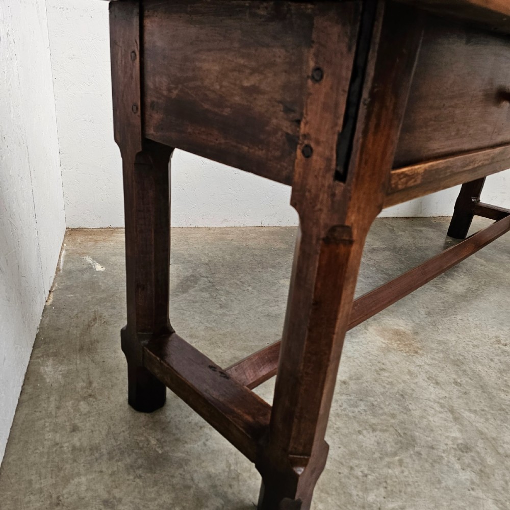 A long 19th-century dark brown wooden bread prep table featuring two drawers with round knobs and a low horizontal stretcher. View VIII