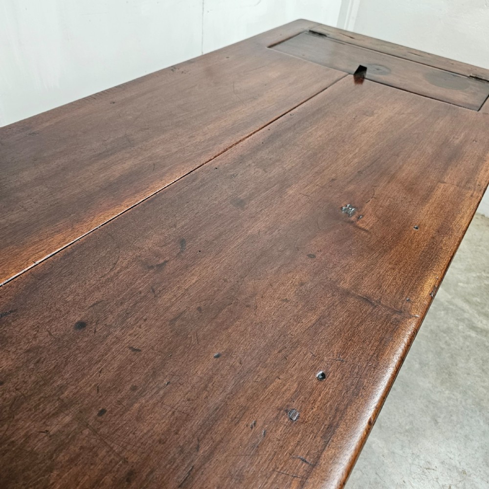 An antique French dark walnut bread prep table featuring a two-board top, side pedestal storage compartment, and lower stretcher base. View III