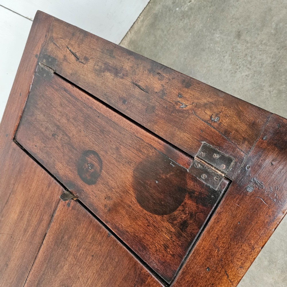 An antique French dark walnut bread prep table featuring a two-board top, side pedestal storage compartment, and lower stretcher base. View V