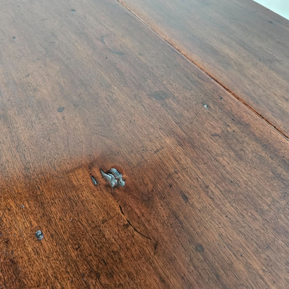 An antique French dark walnut bread prep table featuring a two-board top, side pedestal storage compartment, and lower stretcher base. View VII