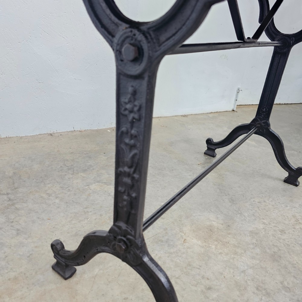 A rectangular natural oak tabletop supported by a black painted iron frame with diagonal cross bracing. View IV