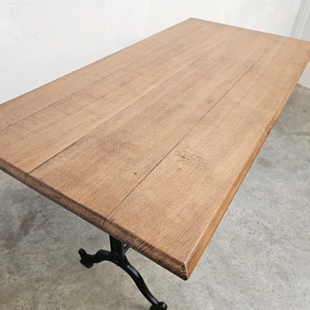 A rectangular natural oak tabletop supported by a black painted iron frame with diagonal cross bracing. View VI