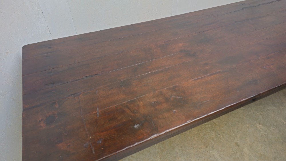 An eight-foot antique French dark oak farmhouse table featuring a plank top, frieze drawer with iron drop handle, and tapered square legs. View V