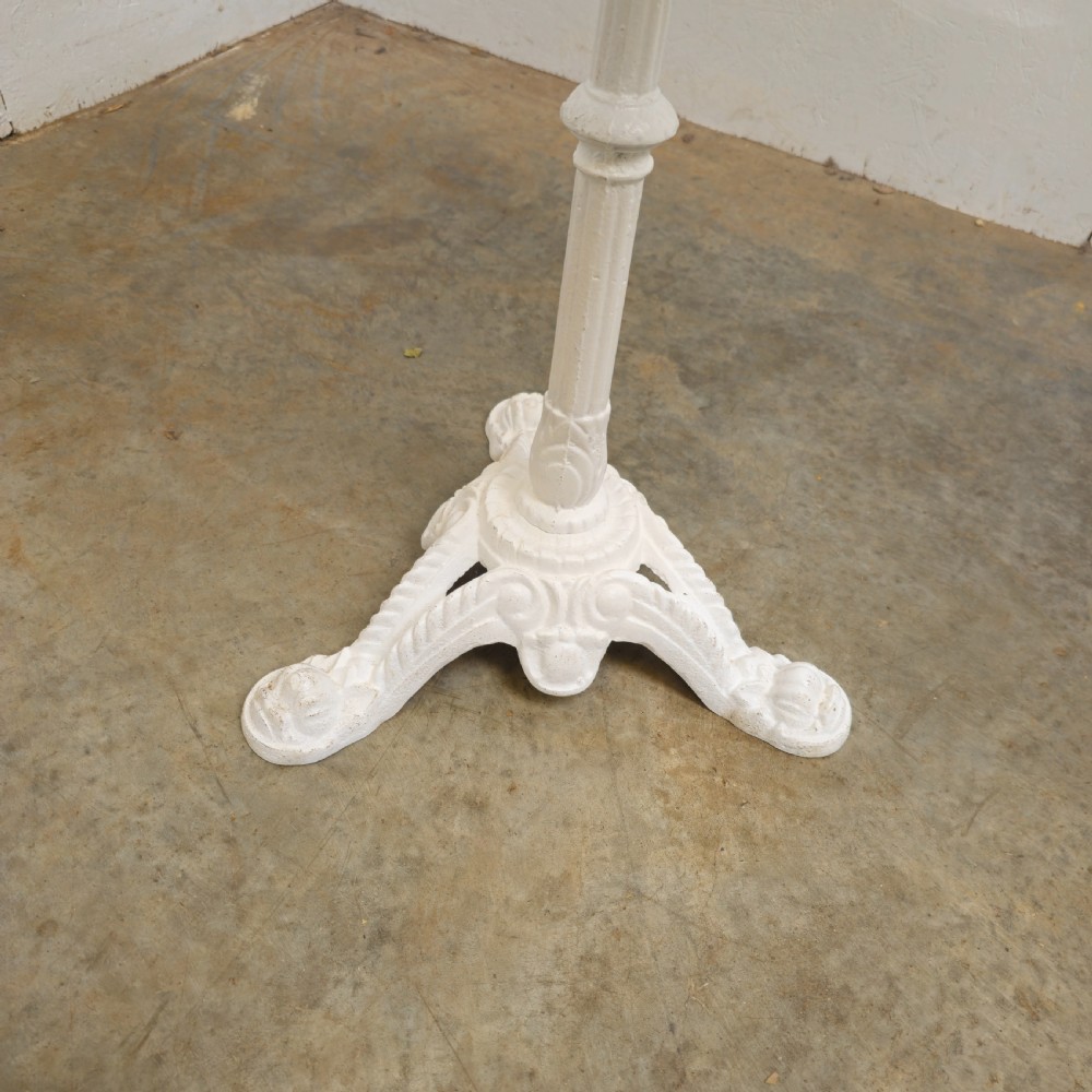 A circular green marble bistro table featuring a white painted cast iron pedestal stem with three decorative feet. View V