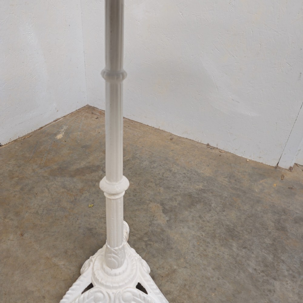 A circular green marble bistro table featuring a white painted cast iron pedestal stem with three decorative feet. View VI