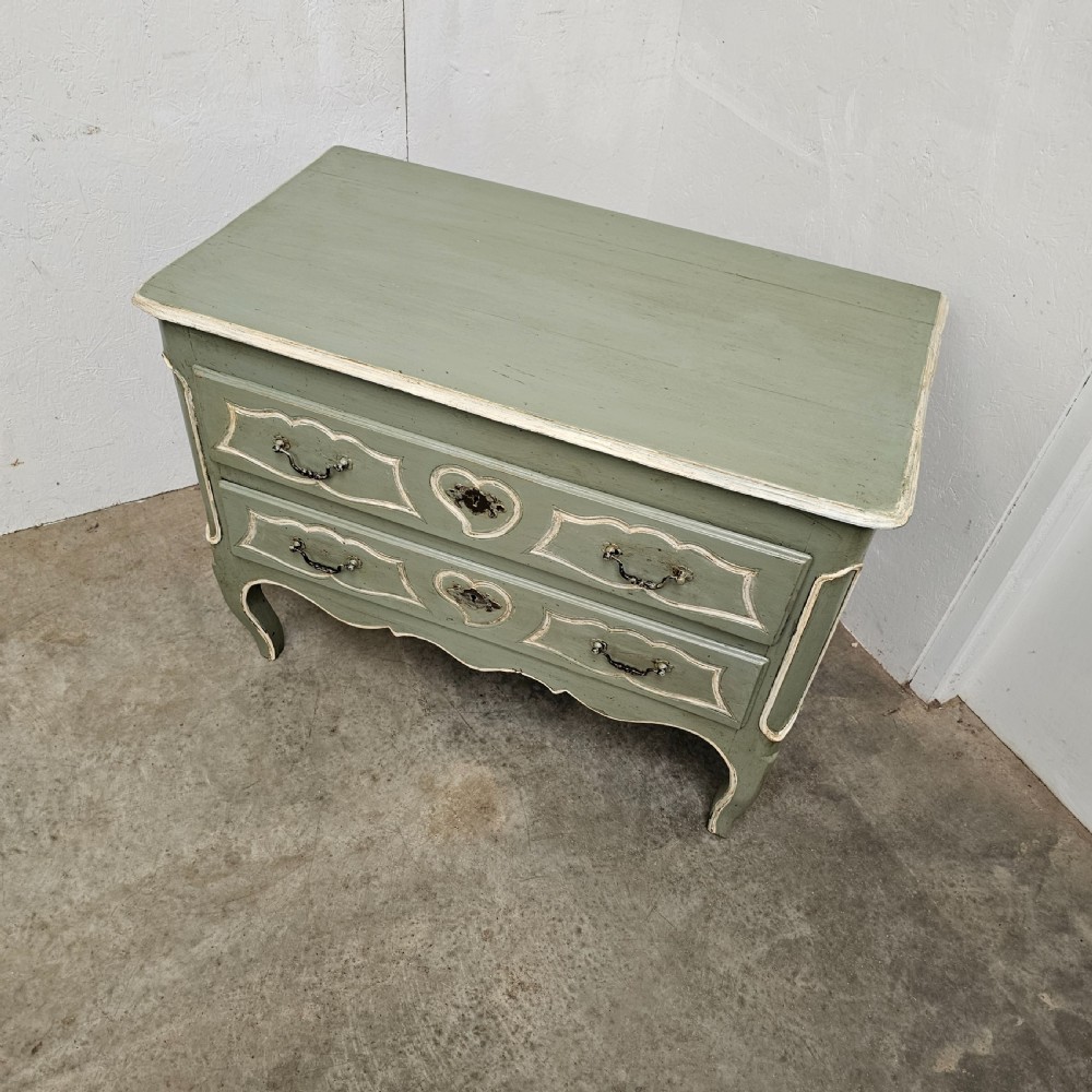 An 18th-century French provincial painted commode featuring two long drawers finished in muted green paint with cream trim and metal handles. View II