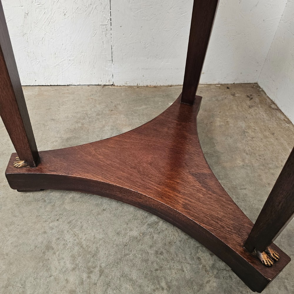 A circular 19th-century French Empire style gueridon featuring a dark marble top supported by tapered mahogany legs adorned with gilt female busts and a triform base. View VII