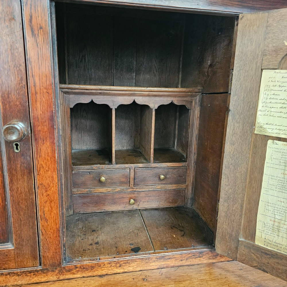 An eighteenth-century dark oak Welsh deuddarn press cupboard featuring three ogee arched upper doors above drawers and fielded lower panel doors. View VII
