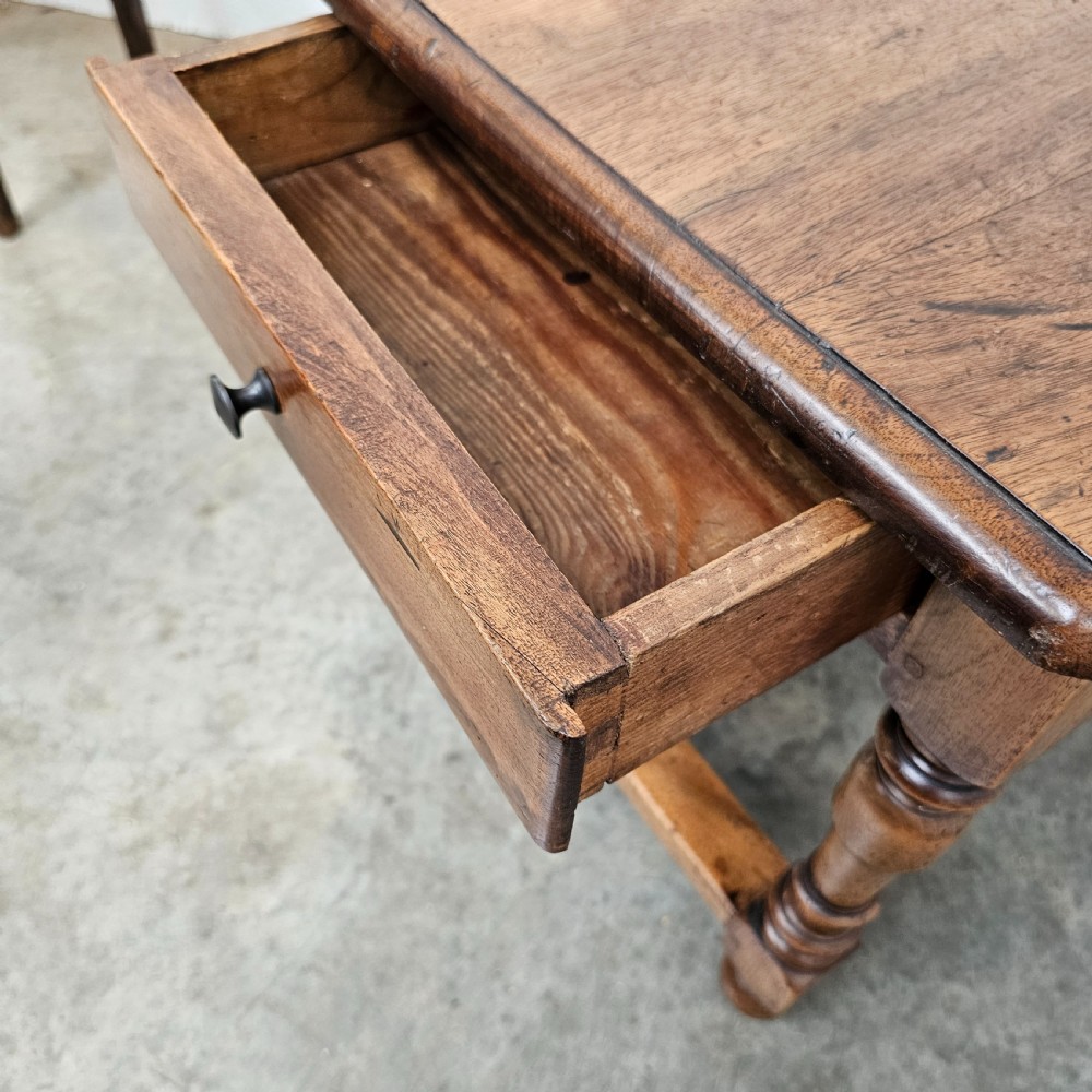 A small antique French walnut end table featuring turned wooden legs, a low stretcher base, and a single drawer with a dark turned knob. View IV