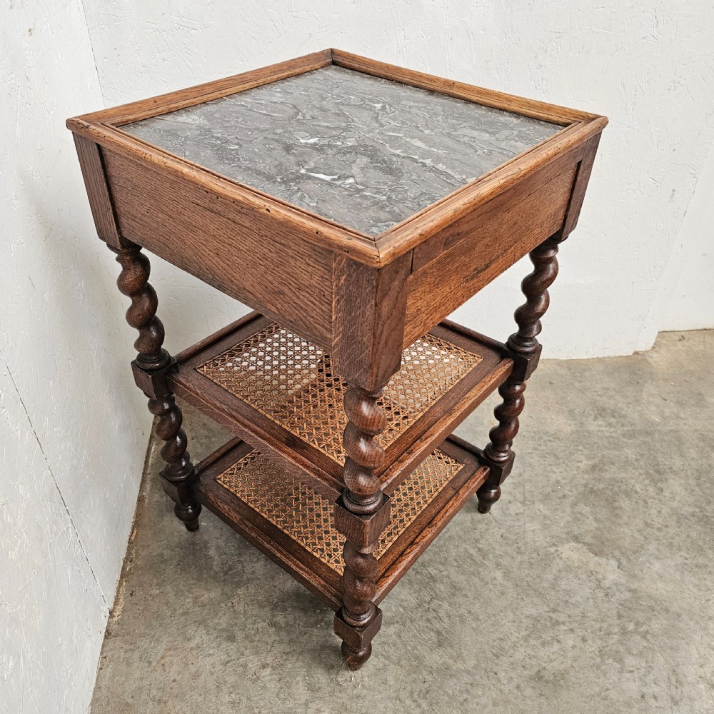 A French oak tiered etagere featuring an inset marble top, two woven cane lower shelves, and turned barley-twist supports. View III