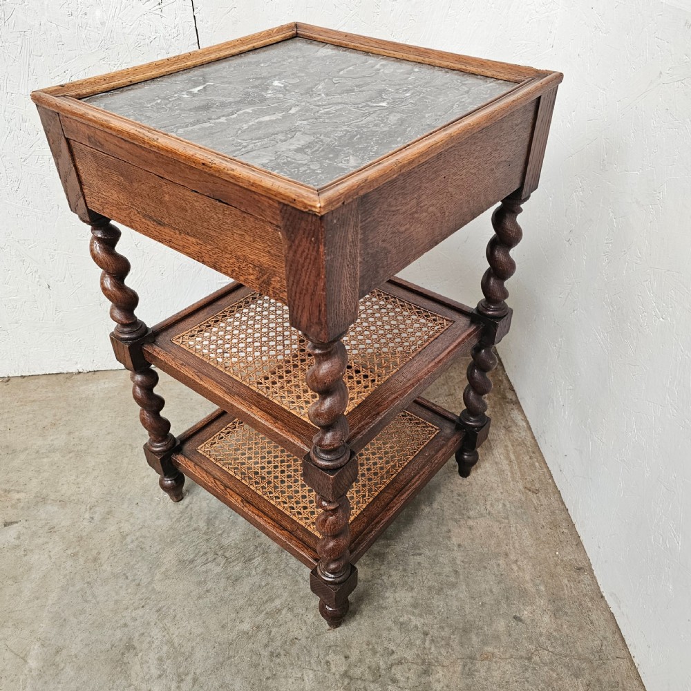 A French oak tiered etagere featuring an inset marble top, two woven cane lower shelves, and turned barley-twist supports. View IV