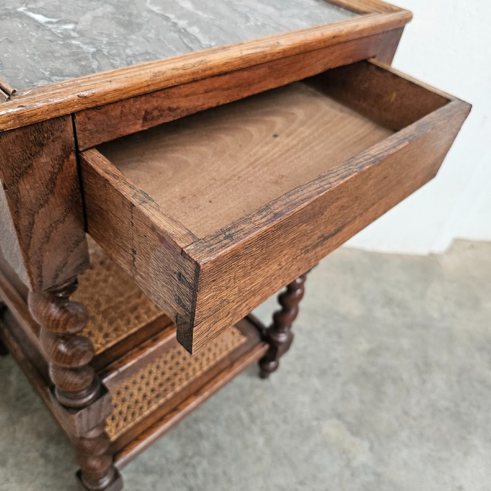 A French oak tiered etagere featuring an inset marble top, two woven cane lower shelves, and turned barley-twist supports. View V
