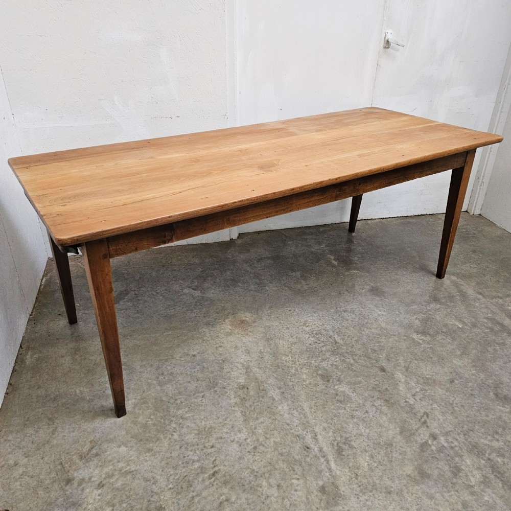 A nineteenth-century French farmhouse table made of faded cherrywood, featuring a rectangular plank top and four square tapered legs. View II
