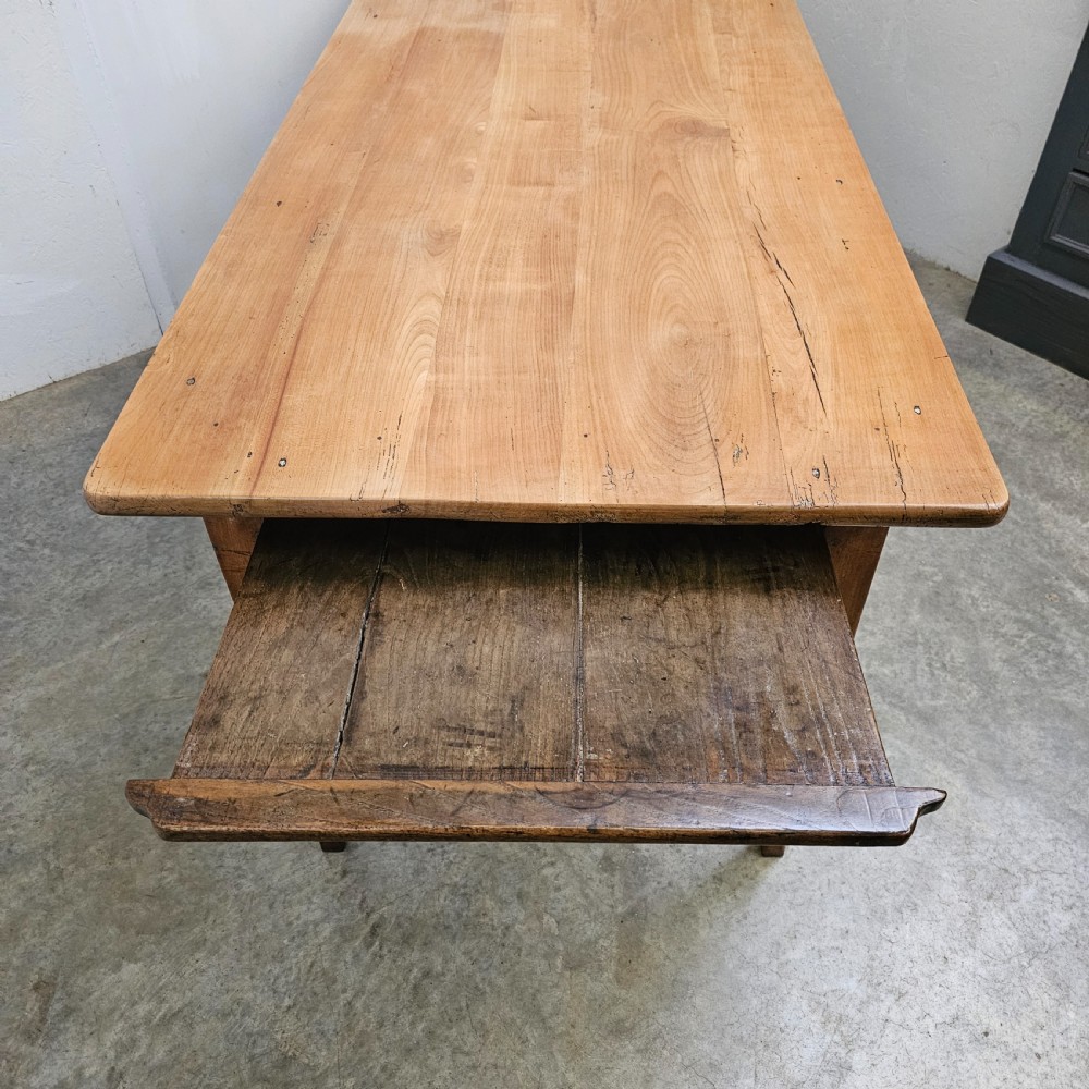 A nineteenth-century French farmhouse table made of faded cherrywood, featuring a rectangular plank top and four square tapered legs. View III
