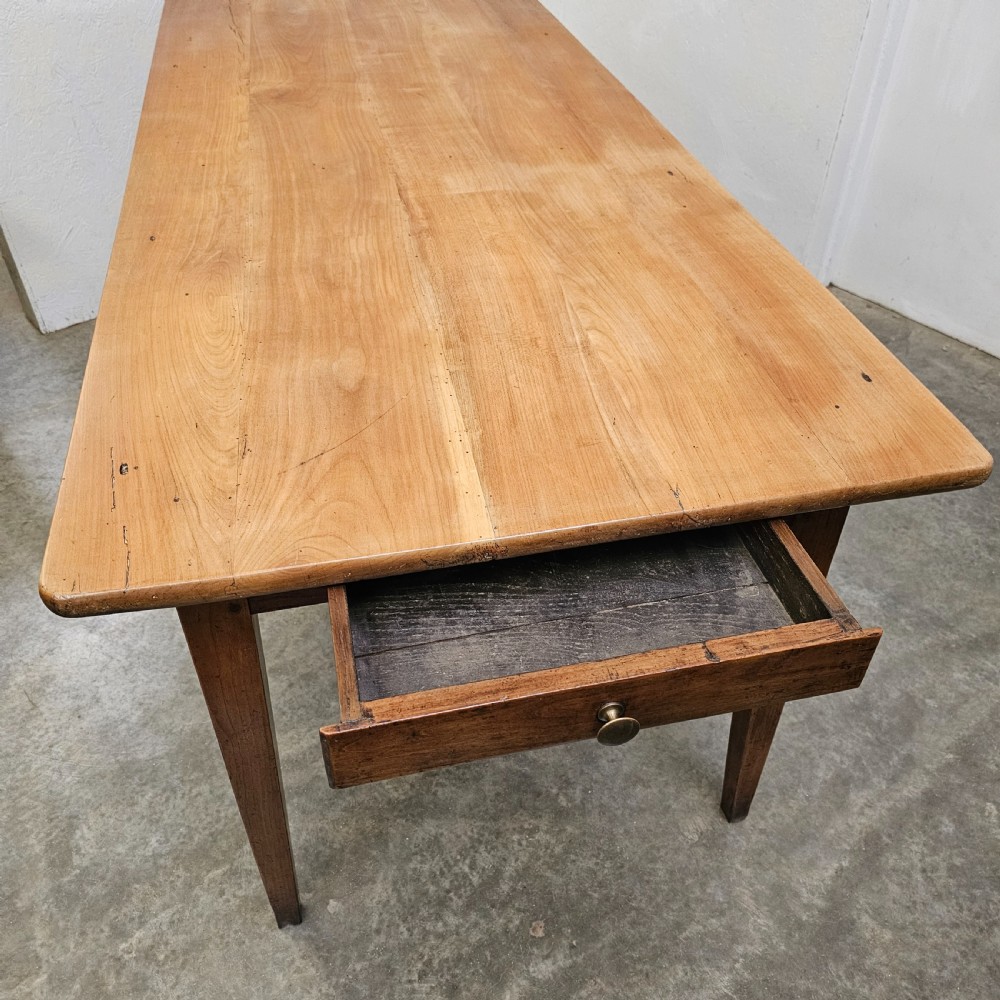 A nineteenth-century French farmhouse table made of faded cherrywood, featuring a rectangular plank top and four square tapered legs. View IV