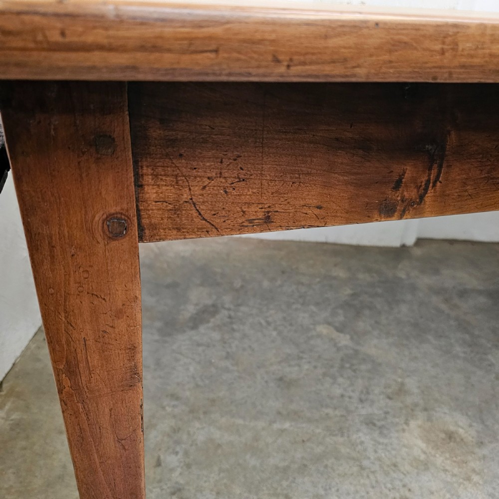 A nineteenth-century French farmhouse table made of faded cherrywood, featuring a rectangular plank top and four square tapered legs. View V