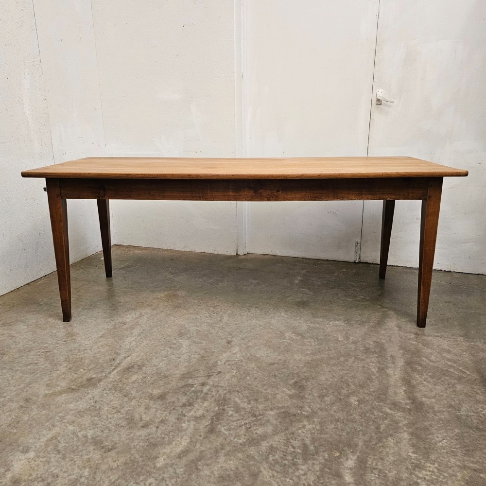 A nineteenth-century French farmhouse table made of faded cherrywood, featuring a rectangular plank top and four square tapered legs. View VI