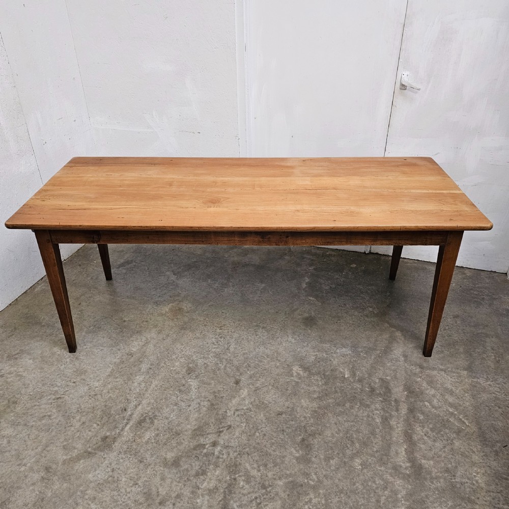 A nineteenth-century French farmhouse table made of faded cherrywood, featuring a rectangular plank top and four square tapered legs. View VII