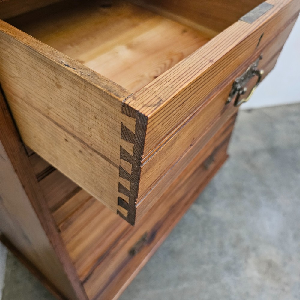 A Victorian pitch pine chest of drawers featuring two short over three long drawers with reeded details, brass handles, and turned bun feet. View VI