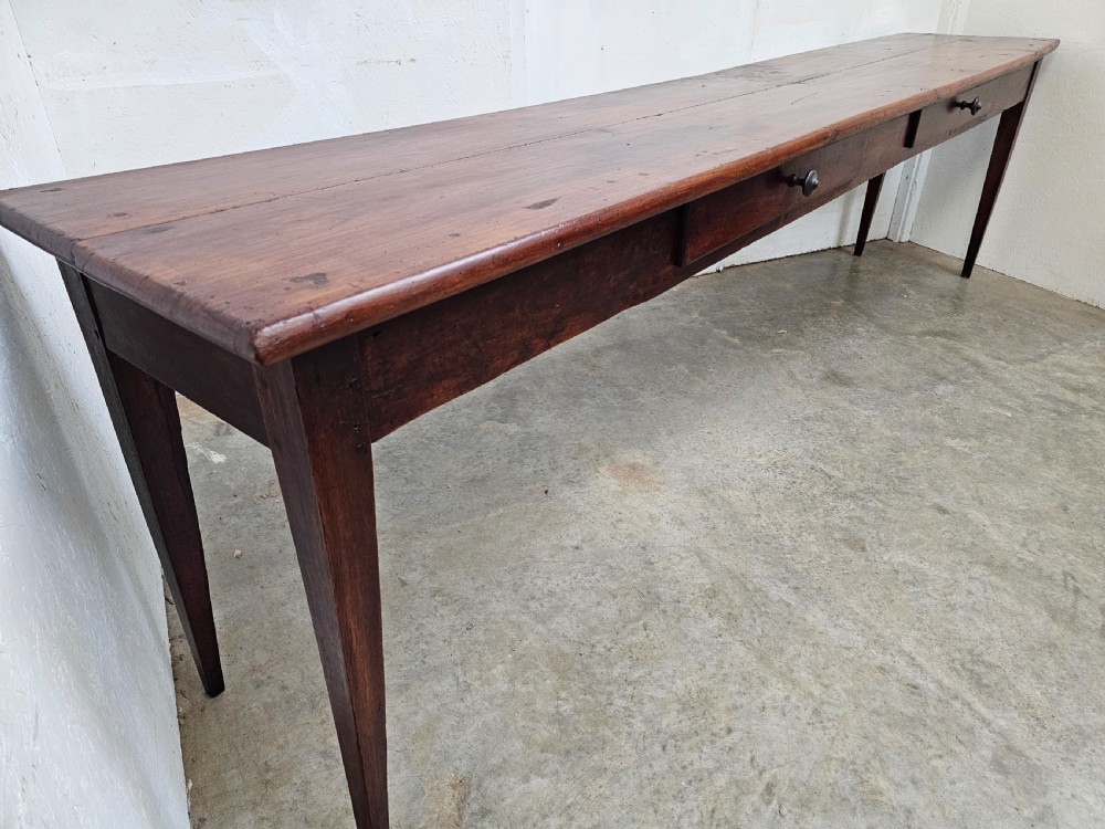 An exceptionally long French rustic wooden console table featuring two frieze drawers and simple tapered legs. View II