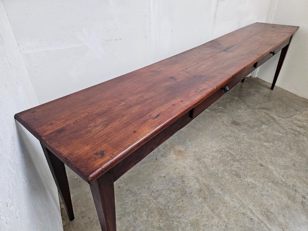 An exceptionally long French rustic wooden console table featuring two frieze drawers and simple tapered legs. View III