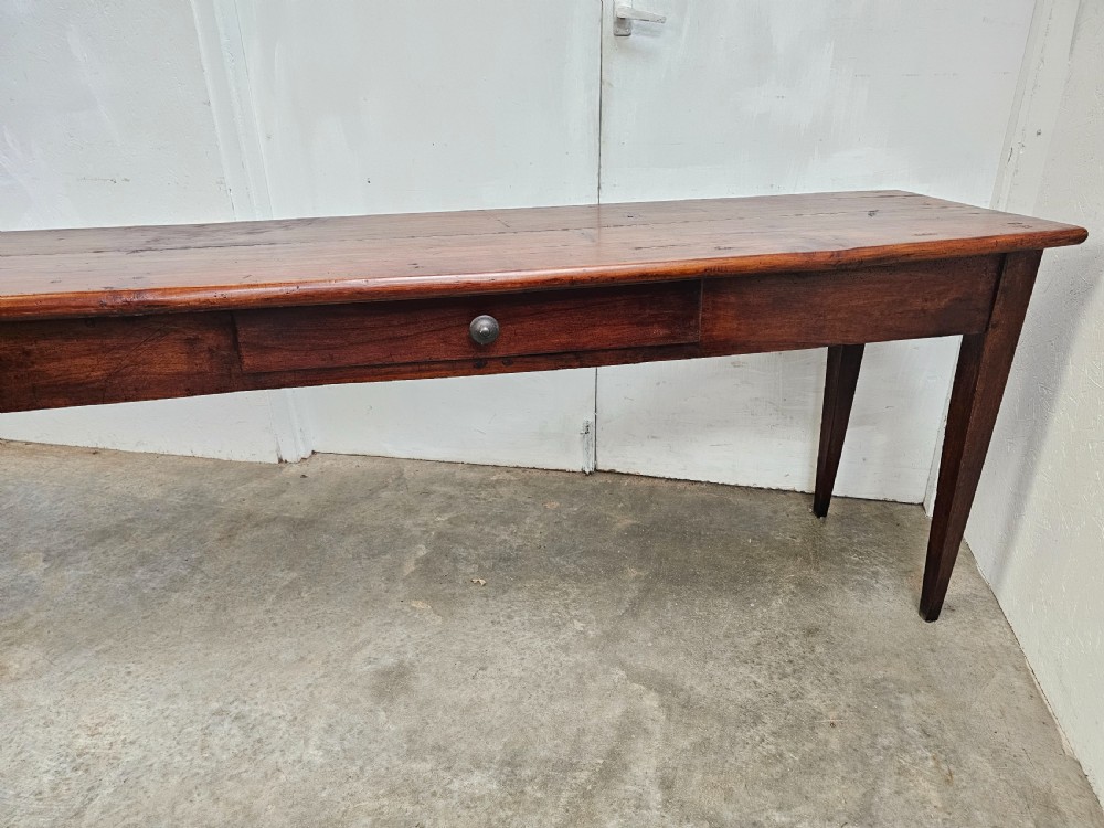 An exceptionally long French rustic wooden console table featuring two frieze drawers and simple tapered legs. View IV