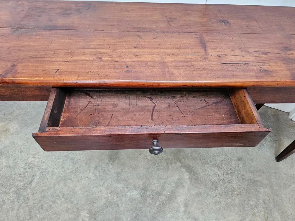 An exceptionally long French rustic wooden console table featuring two frieze drawers and simple tapered legs. View VI