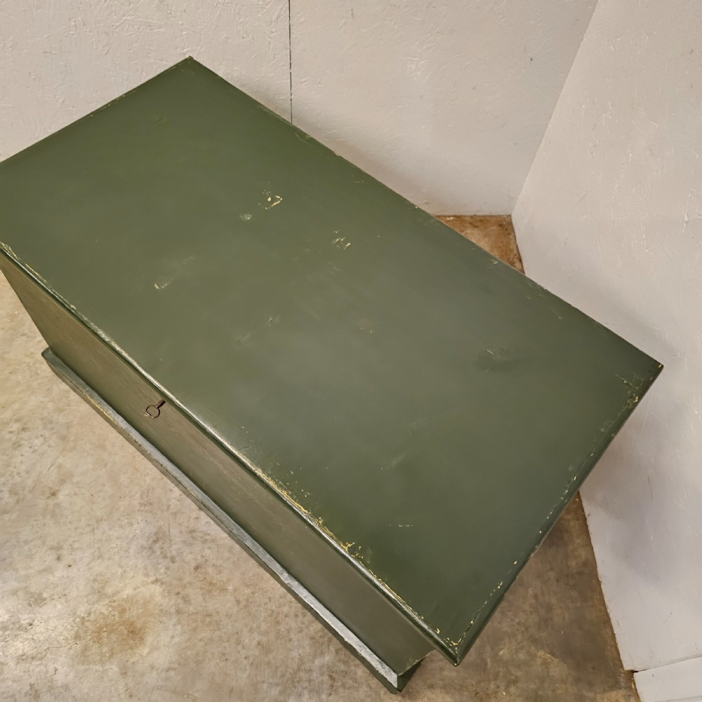 A rectangular green painted pine blanket box with side iron handles, a key in the lock, and a solid plinth base. View III