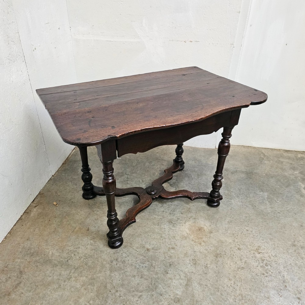 An 18th-century dark walnut side table featuring turned legs, a shaped lower apron, a moulded top, and a curved X-frame stretcher. View II
