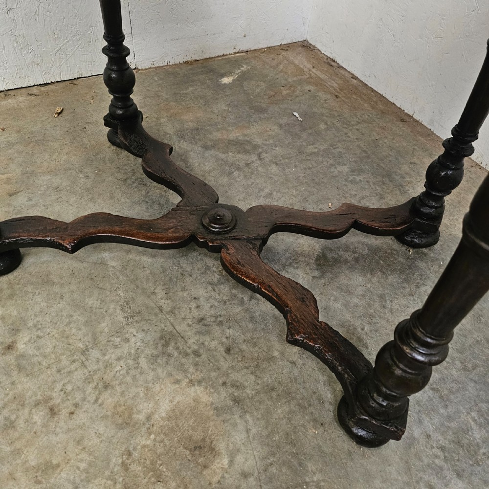 An 18th-century dark walnut side table featuring turned legs, a shaped lower apron, a moulded top, and a curved X-frame stretcher. View IV