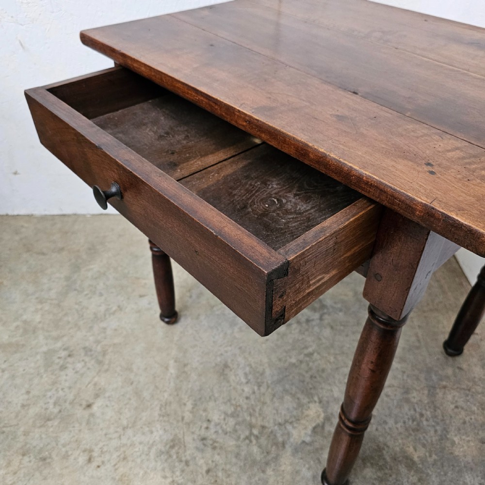 An early 19th-century walnut lamp table featuring a single drawer with a dark wooden knob handle and four turned legs. View IV