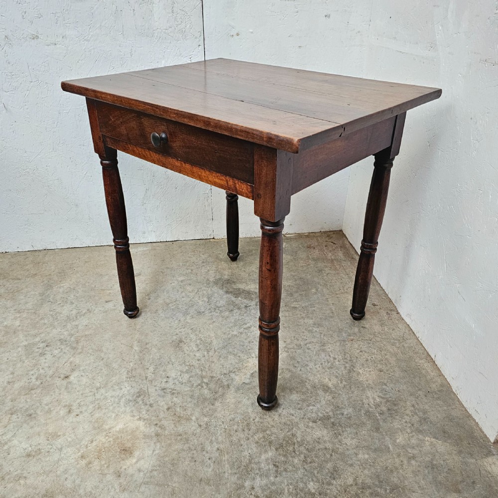 An early 19th-century walnut lamp table featuring a single drawer with a dark wooden knob handle and four turned legs. View II