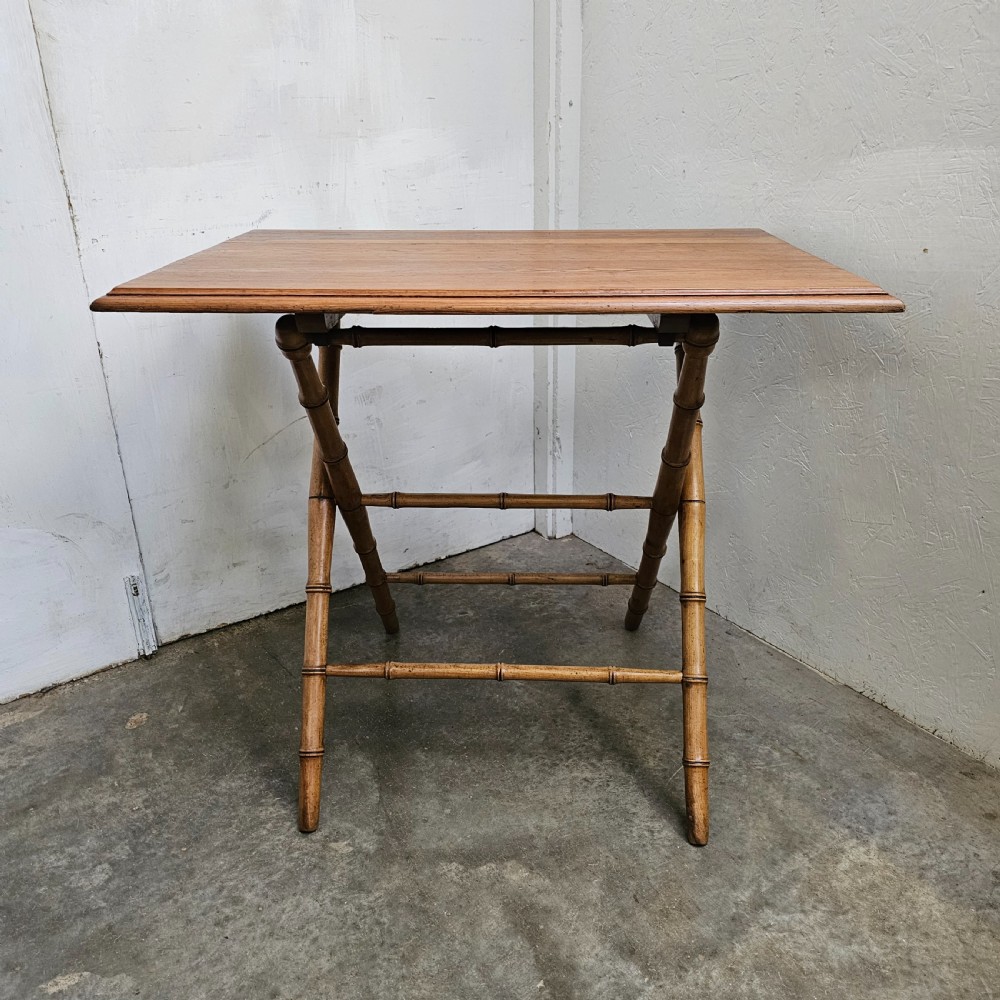 A French folding side table featuring turned wood legs shaped to resemble bamboo stalks and a smooth rectangular top.