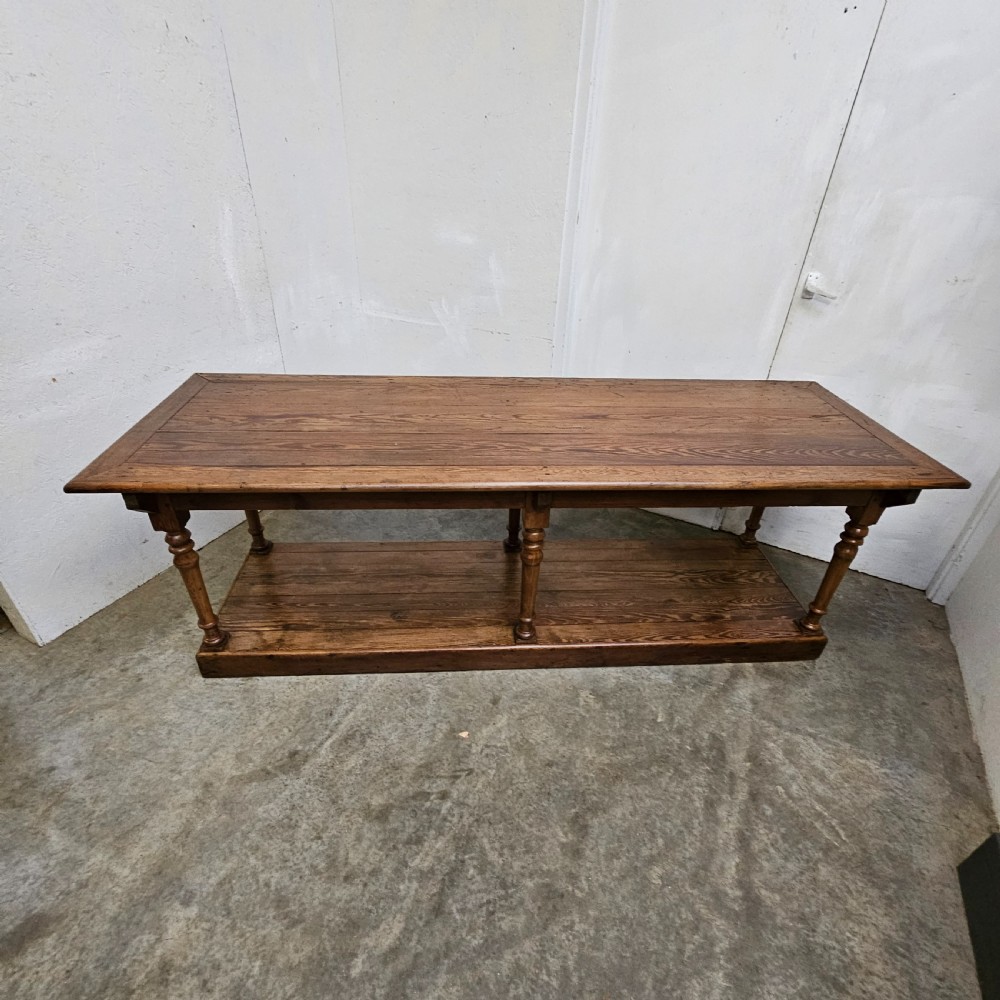 A 19th-century French pine drapers table featuring a long plank top, six turned legs, and a full-length lower pot board shelf. View II