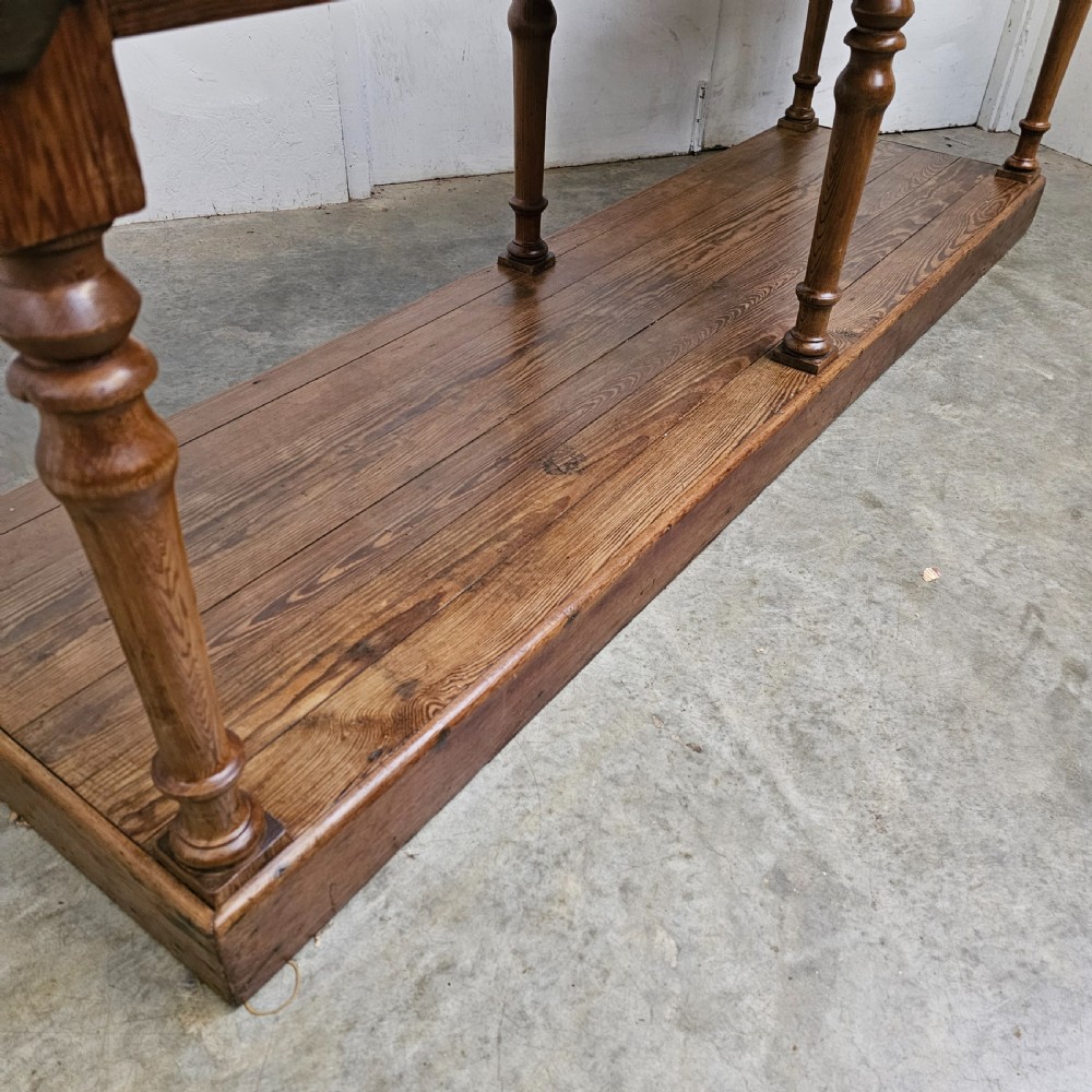 A 19th-century French pine drapers table featuring a long plank top, six turned legs, and a full-length lower pot board shelf. View IV
