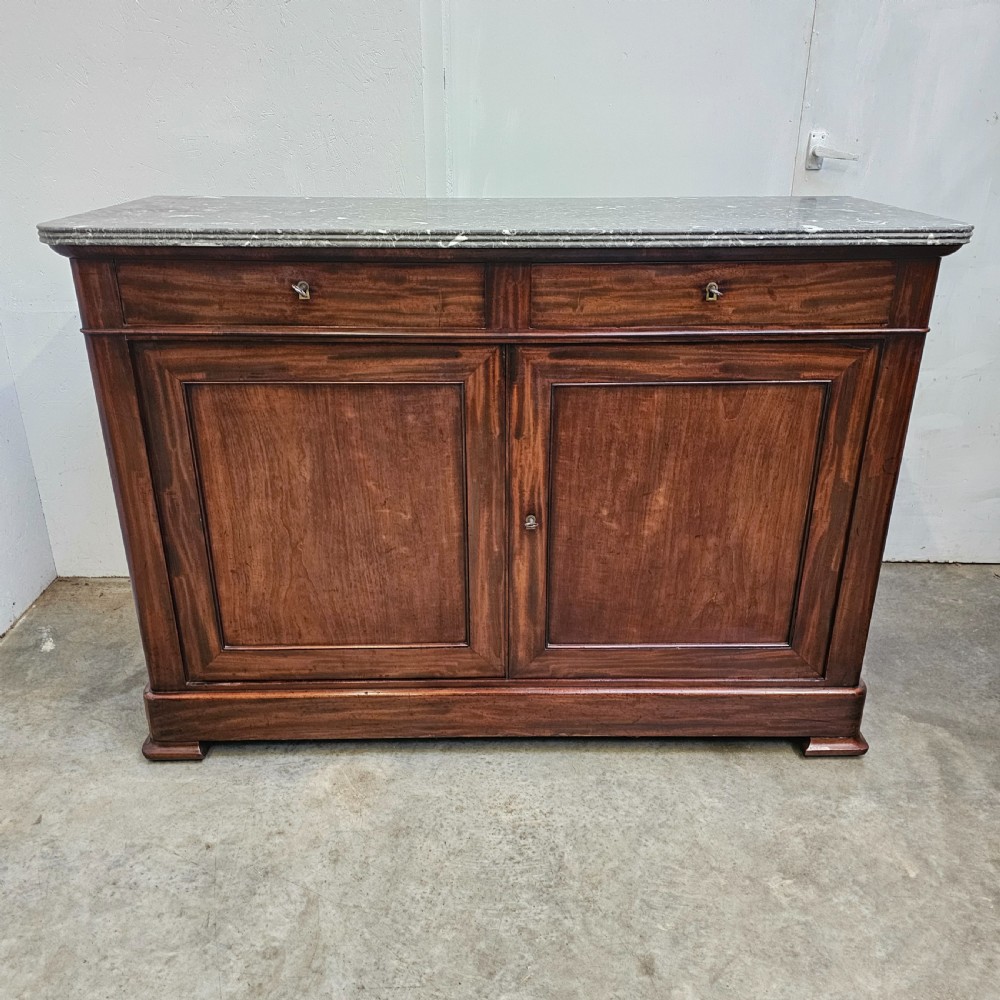 A French Louis Philippe style mahogany buffet with a grey veined marble top, two upper drawers, and two panelled cabinet doors.