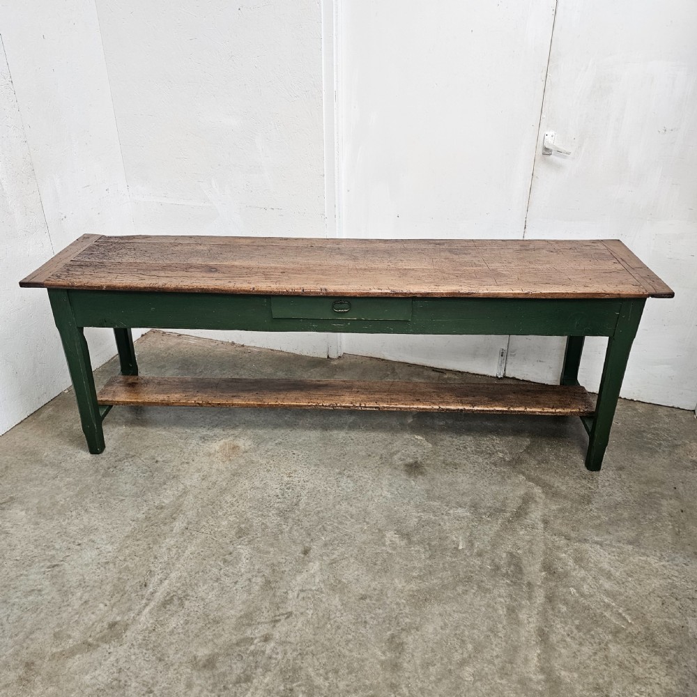 A long rustic French serving table featuring a dark green painted wooden frame, a single drawer with an iron pull, a natural wood top, and a lower pot shelf. View III