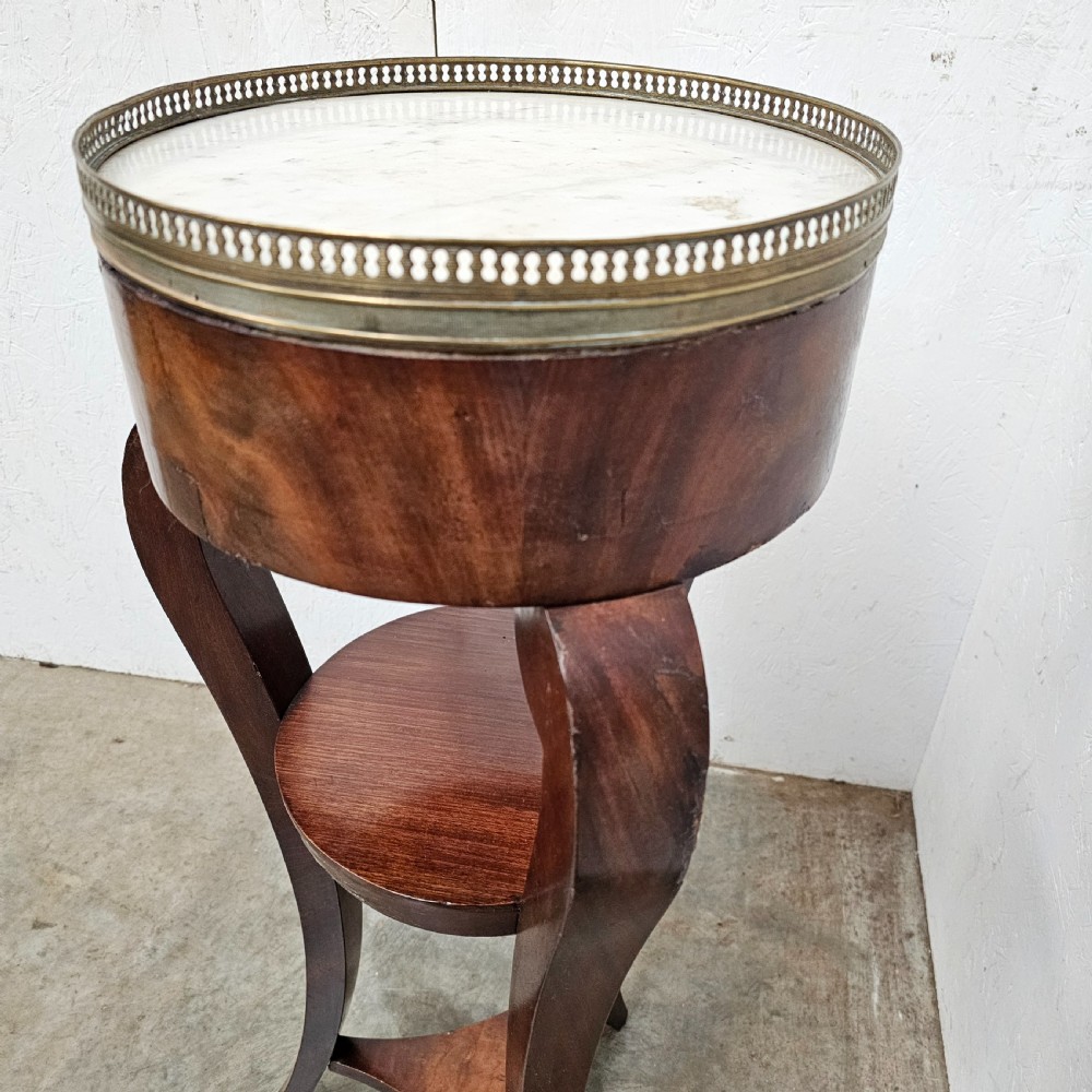 A tall French mahogany tripod stand featuring an inset circular white marble top with a pierced brass gallery and a lower circular shelf. View II