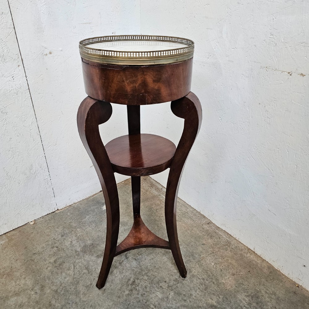 A tall French mahogany tripod stand featuring an inset circular white marble top with a pierced brass gallery and a lower circular shelf. View IV