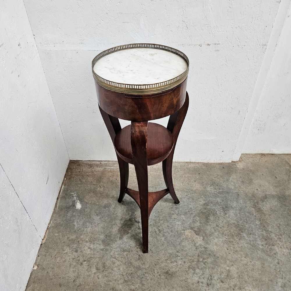 A tall French mahogany tripod stand featuring an inset circular white marble top with a pierced brass gallery and a lower circular shelf. View V