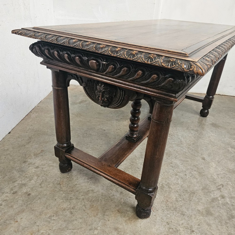 A rectangular dark walnut centre table featuring a deeply carved egg-and-dart frieze, turned column legs, and a central stretcher with spindle supports. View III