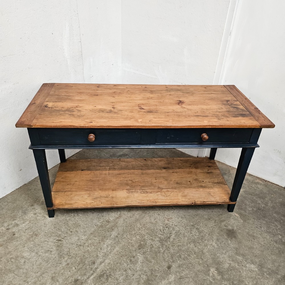 A French two-tier wooden work table featuring a dark blue painted frame, two drawers with round wooden handles, and natural light wood top and lower shelf. View II