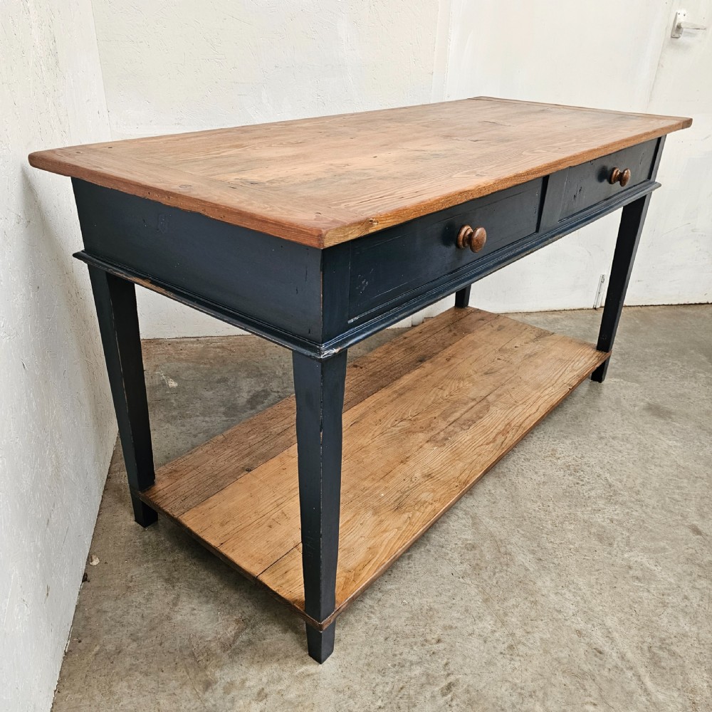 A French two-tier wooden work table featuring a dark blue painted frame, two drawers with round wooden handles, and natural light wood top and lower shelf. View III